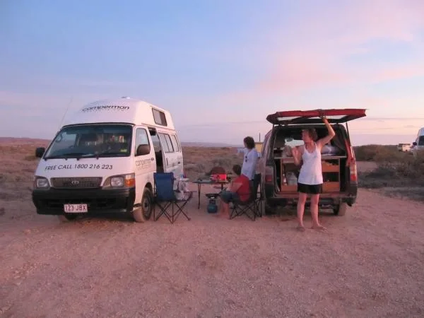 Two Camperman branded campervans set up for the night in the Australian outback at sunset
