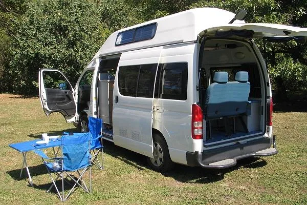 Camperman Paradise Family 5 hi-top campervan parked on grass with mountain backdrop